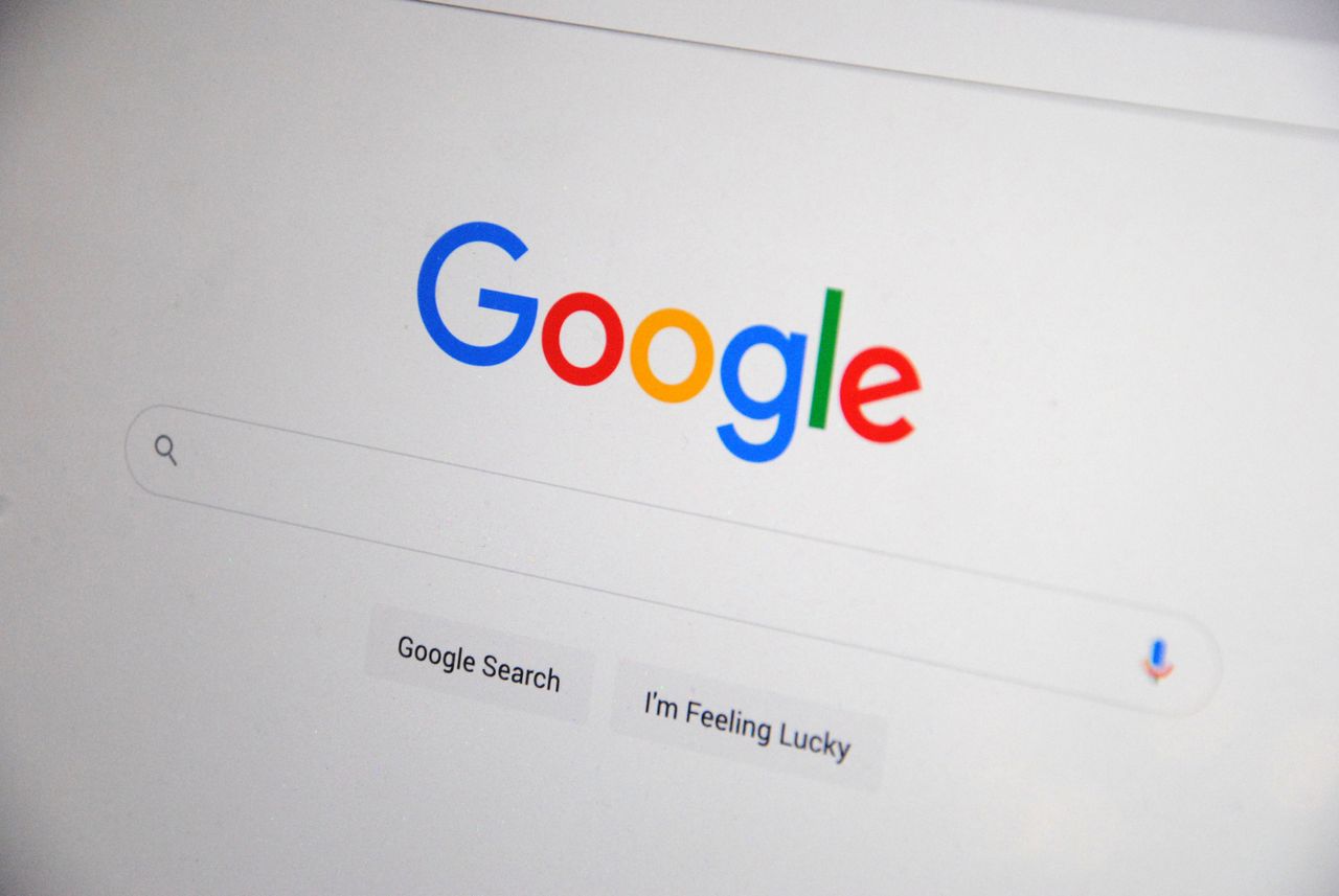 who-we-are Close-up of the Google homepage on a screen showing search options.