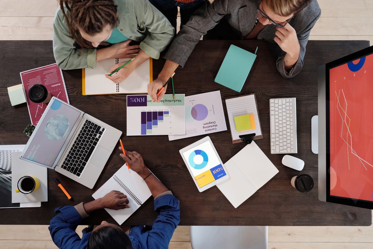 our-story Overhead view of a diverse team collaborating on a project in a modern office setting.