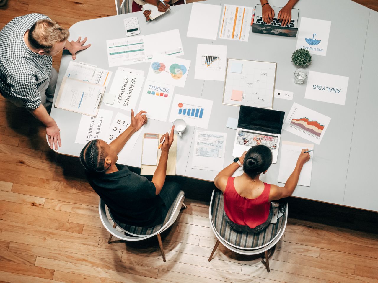 Crafting Captivating Headlines: Your awesome post title goes here Top view of diverse colleagues in a business meeting discussing strategies with charts and laptops.